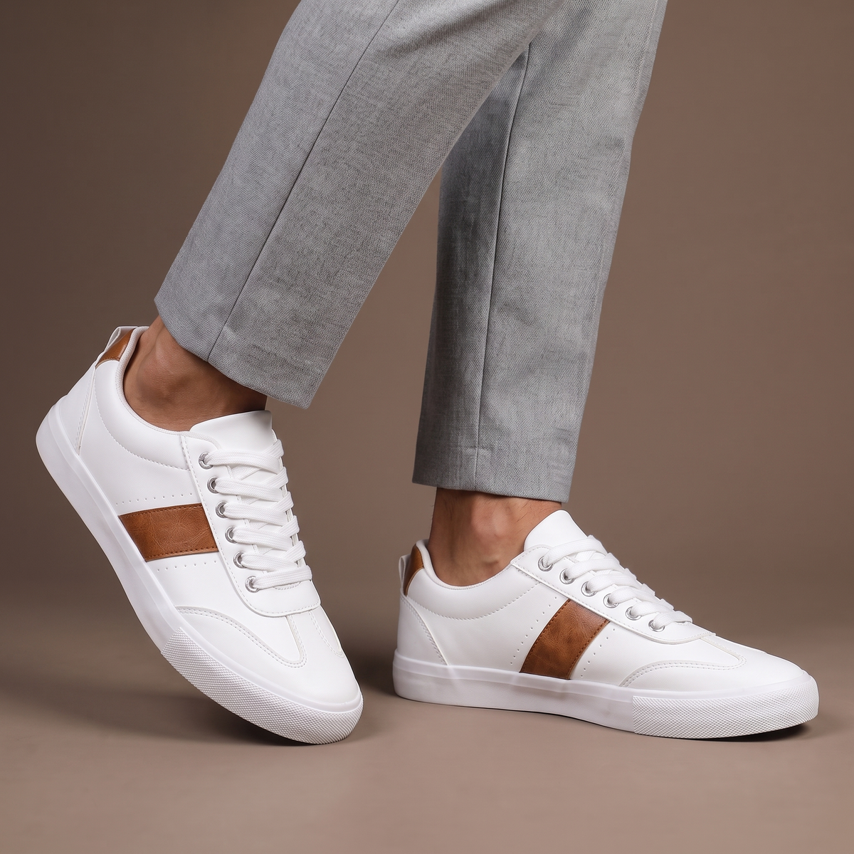 Men's white casual low-top sneakers with brown detail - worn view